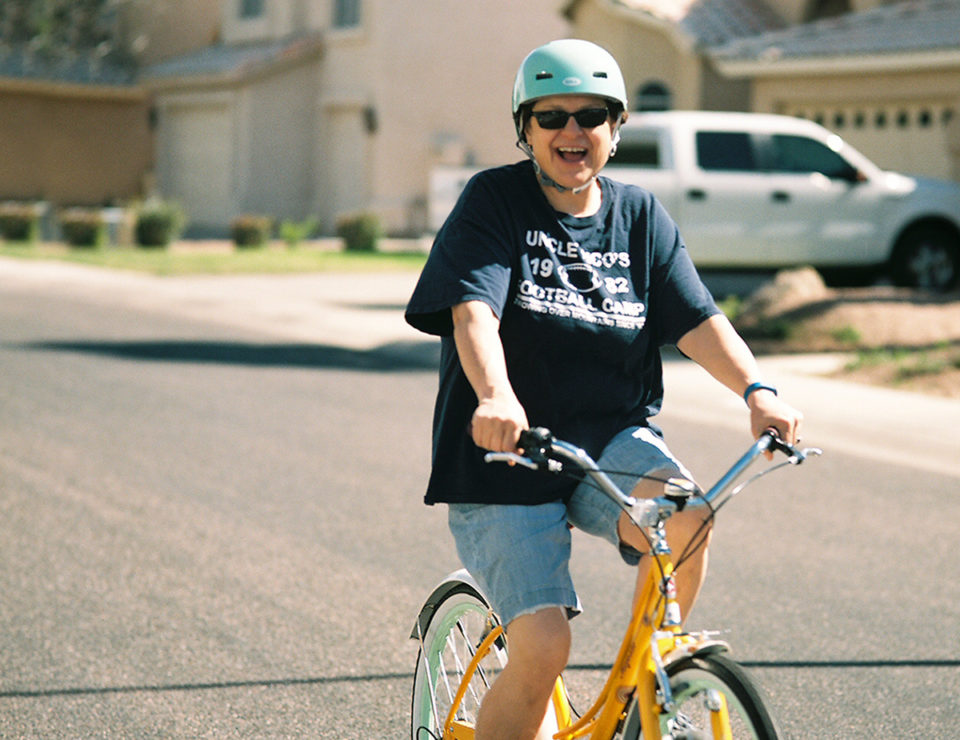 Mature senior woman riding a bike happy